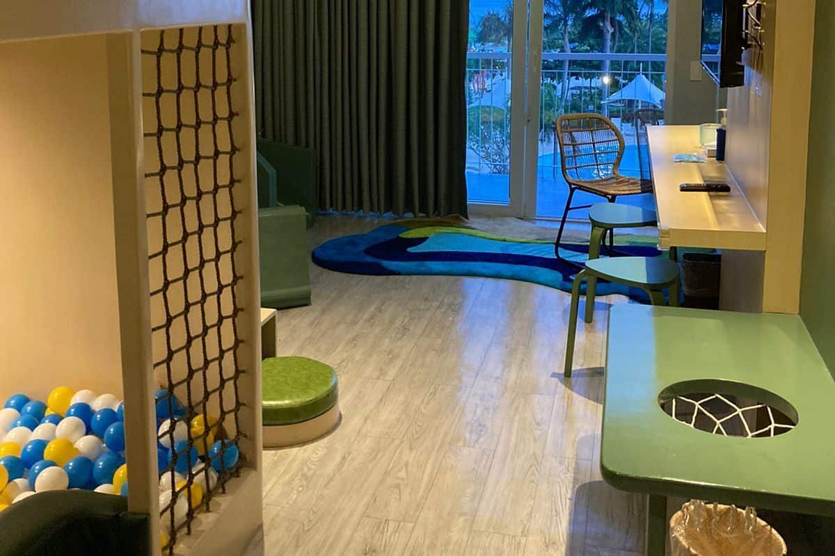 Una habitación de hotel moderna con balcón, mesa de billar y televisor.