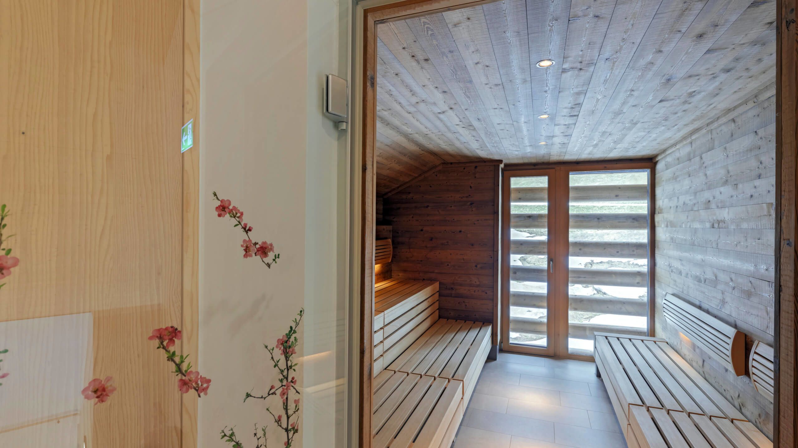 A sauna room with wooden benches and a sloped ceiling.