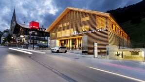 A building with a sloped roof and wooden facade, labeled 'open select partnerships'. - alpen select apartments Kleinwalsertal (Mittelberg)