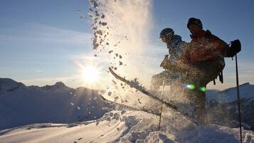 A snowy mountain landscape with a ski slope and a skier in motion.