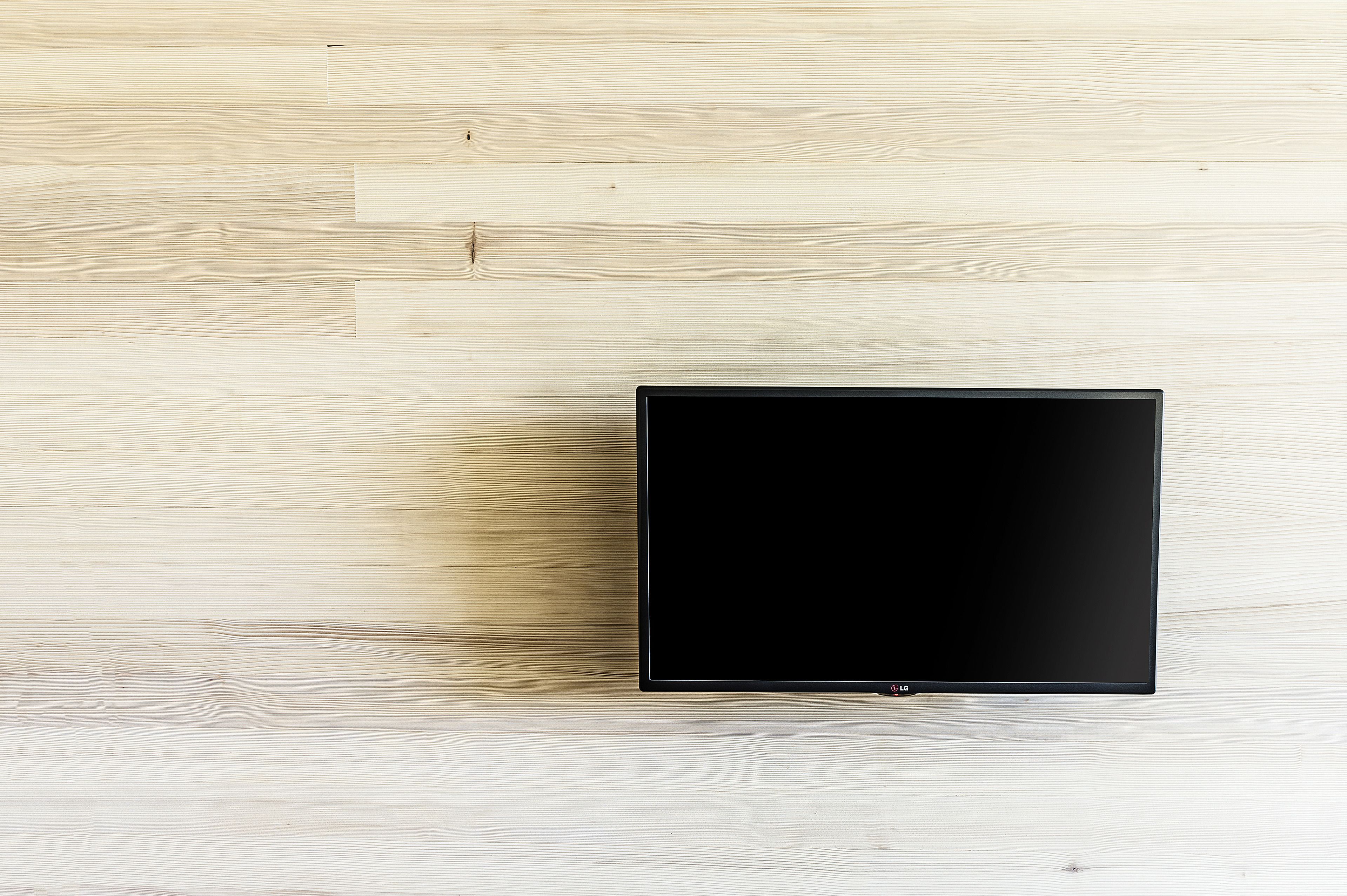 A flat-screen TV on a light wooden floor.