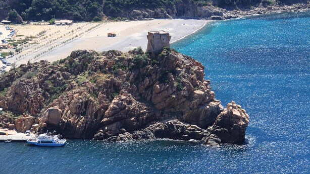 A coastal landscape with a rocky island, a beach, and a clear blue sea. - Hôtel le Subrini (Ota)