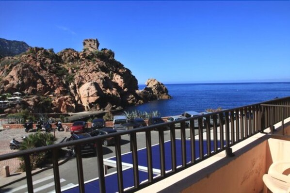 A coastal view with rocky terrain and a clear blue sky.