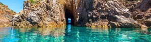 L’entrée d’une grotte côtière, avec une eau turquoise et limpide.