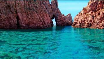 Escena costera con agua turquesa cristalina y acantilados rocosos.
