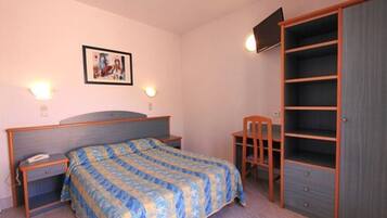 A bedroom with a bed, bedside tables, a chair, a wardrobe, and a wall-mounted TV.