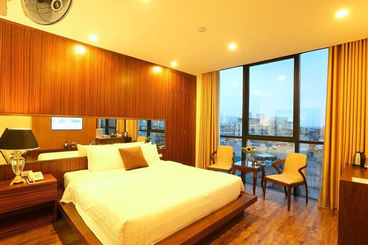 Ein Hotelzimmer mit einem großen Bett, Holzwandverkleidung, Blick auf die Stadt, einem Schreibtisch und einem Stuhl.