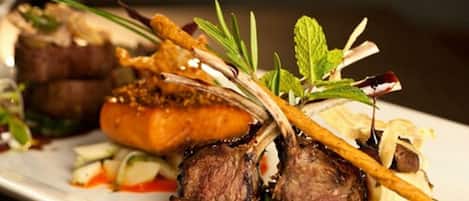 A plated dish with meat, vegetables, and garnishes.