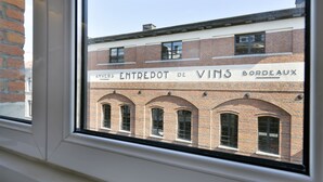 Un edificio con un cartello che riporta la scritta "ANVERS ENTREPOT DE VINS BORDEAUX".