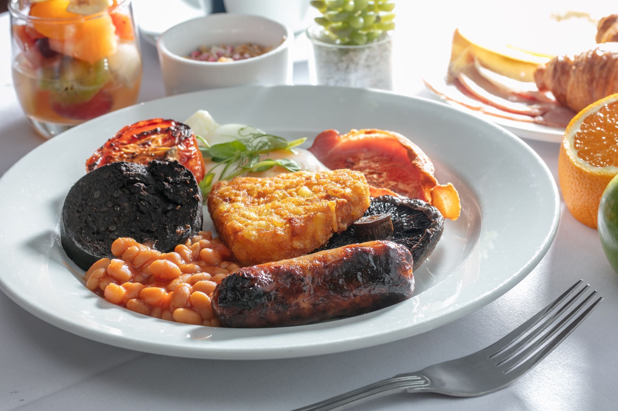 A plate of food including grilled meat, beans, and vegetables.