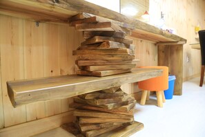 Ein Holzregal mit einem Stapel flacher Holzbretter.