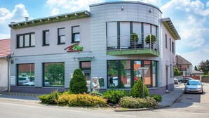 A two-story building with a restaurant named "Fine" on the ground floor. - Fine Restaurant & Apartments (Malacky)