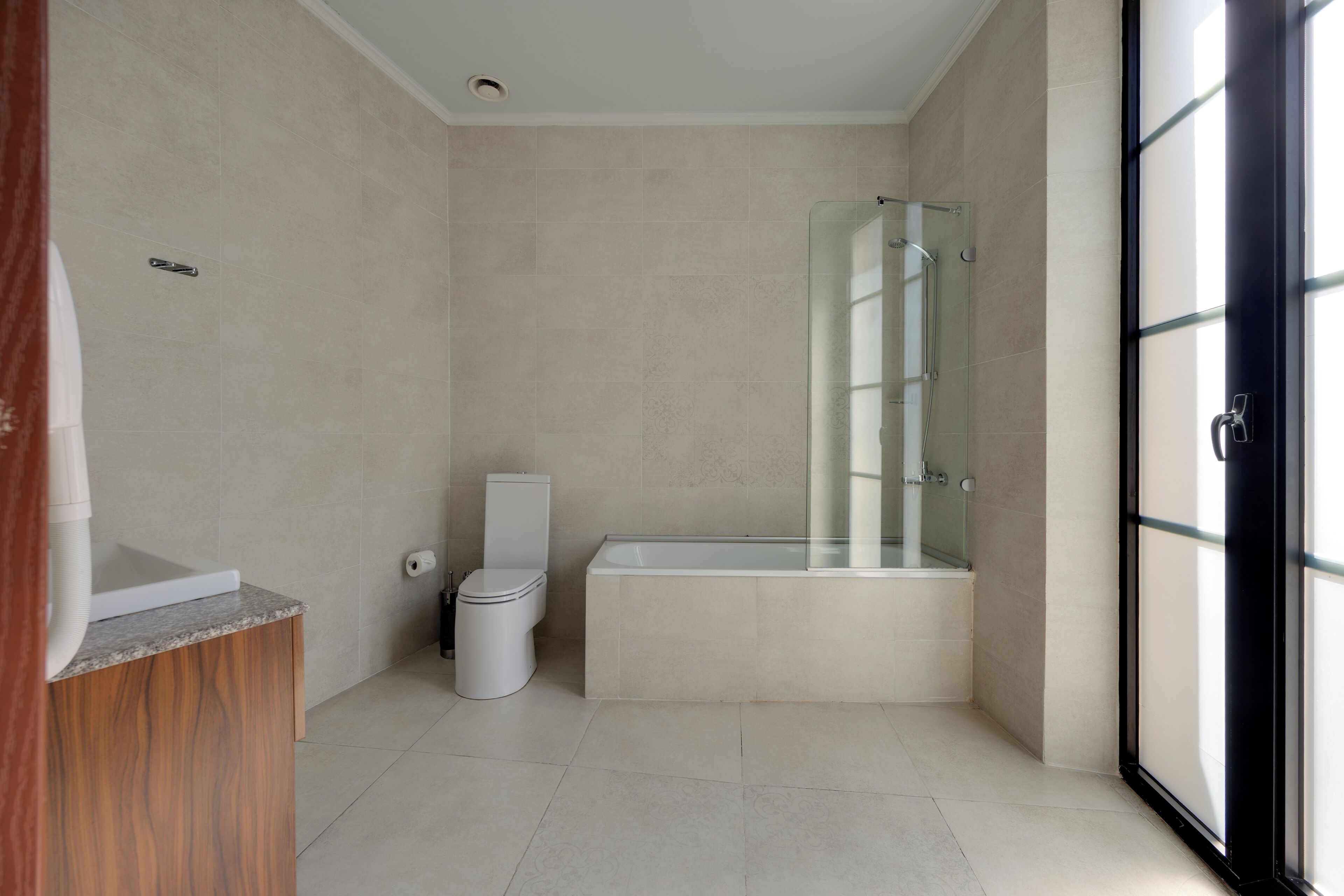 Un bagno moderno con il water, una vasca e uno spazio doccia in vetro.