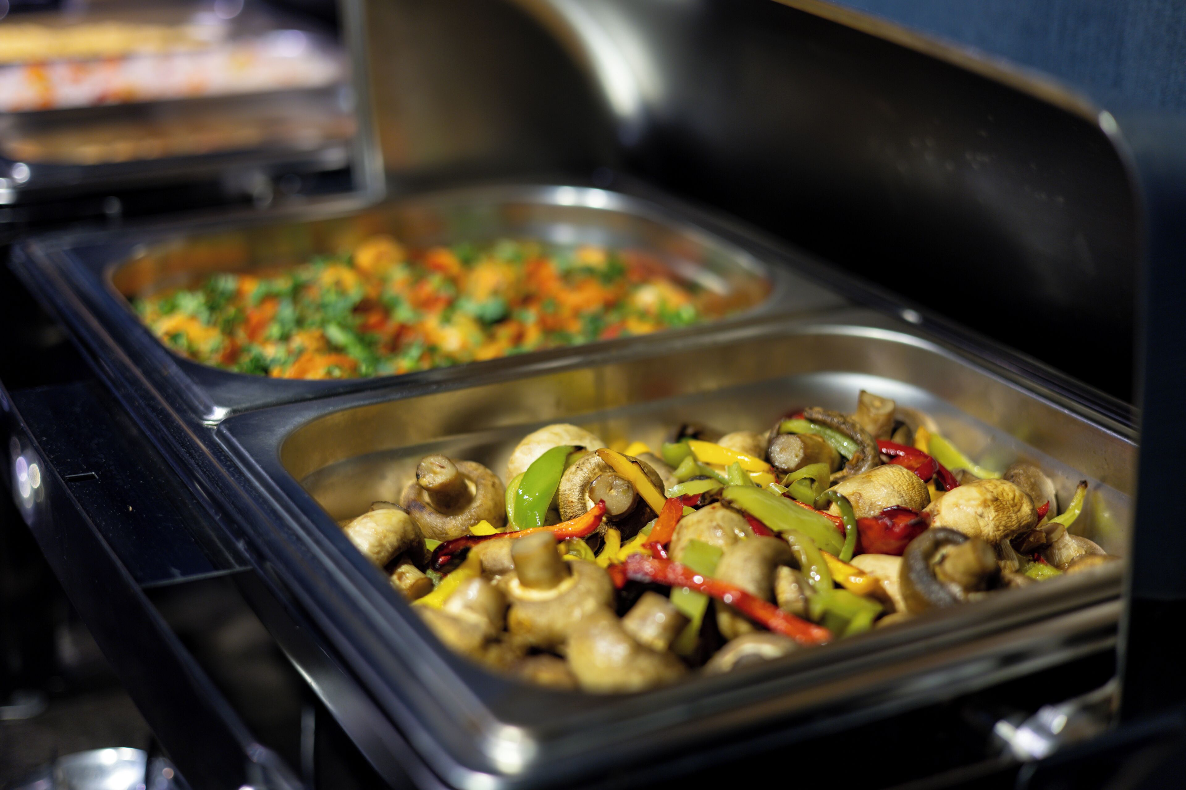 A buffet with various dishes, including mushrooms and vegetables.