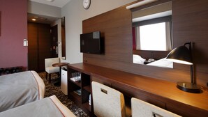 A hotel room with two beds, a desk with a flat-screen TV, a mirror, a lamp, and a clock on the wall. - Hotel Monte Hermana Fukuoka (Fukuoka)