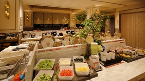A buffet with various food items and a decorative plant. - Hotel Monte Hermana Fukuoka (Fukuoka)