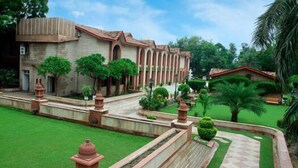 A building with a symmetrical facade, arched windows, and a central courtyard with a fountain. - Ashok Country Resort (New Delhi)