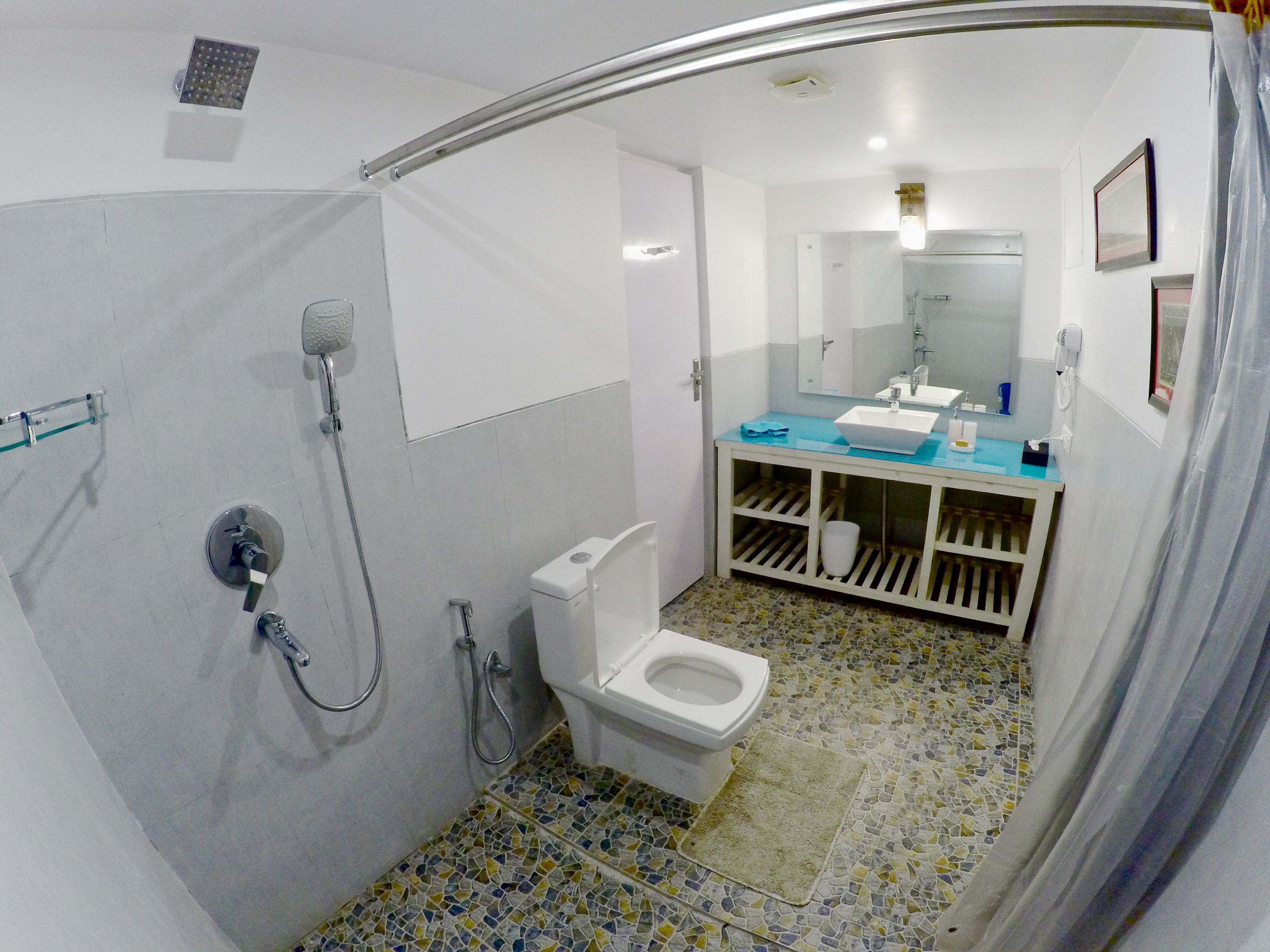 A bathroom with a shower, toilet, and sink.