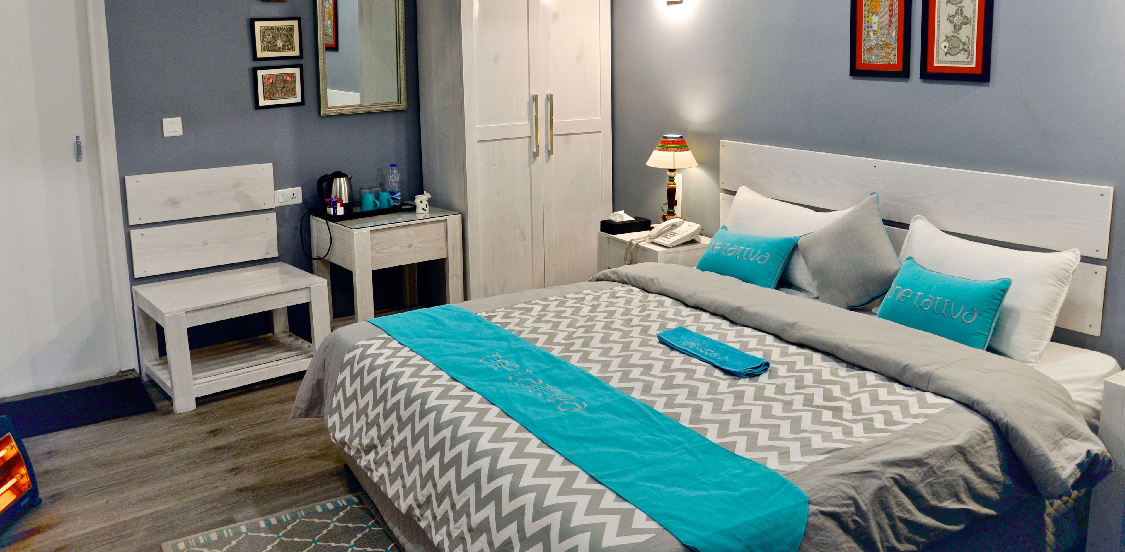 A neatly arranged hotel room with a bed, bedside table, and a small desk.