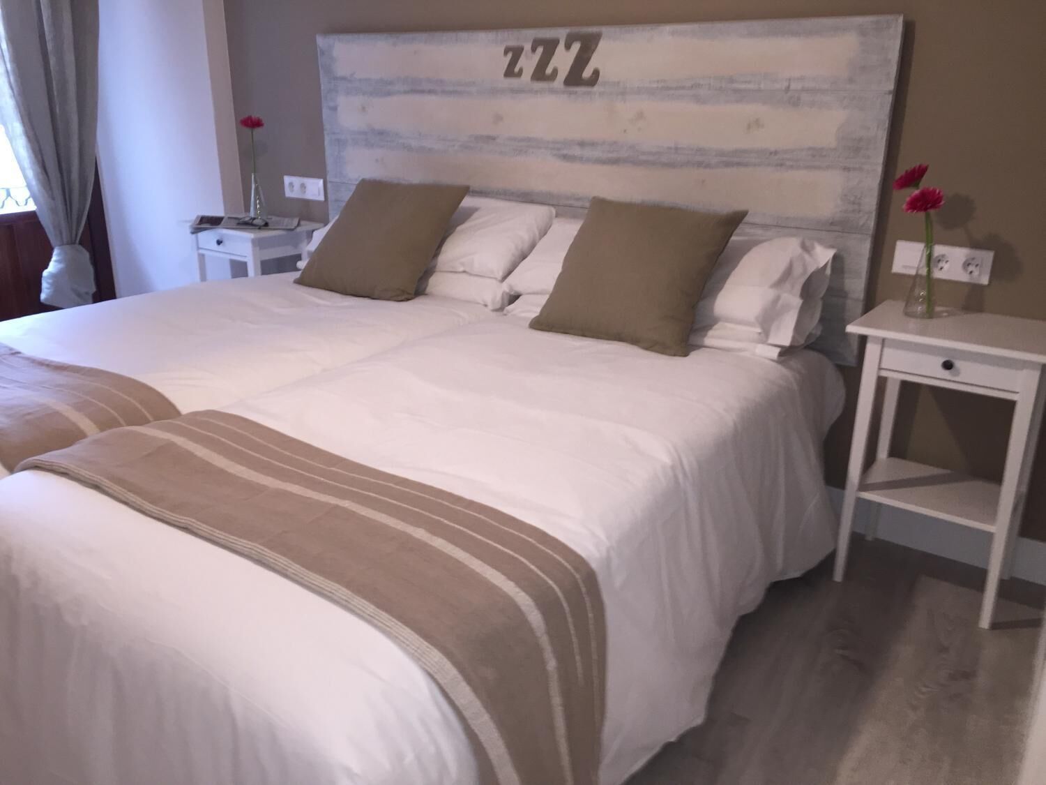 A large bed with a headboard displaying the letters "ZZZ".