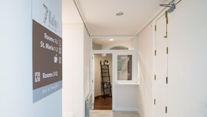 A hotel hallway with signs indicating rooms 1-2, 3-12, and bed & breakfast options. - 7 Kale Bed and Breakfast (Bilbao)