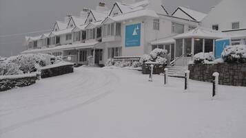 Una hilera de casas blancas con un letrero que dice 'The Trearddur Bay Hotel' en el centro.