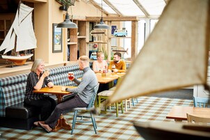 Un café acogedor con suelo a cuadros, muebles de madera y una decoración náutica.