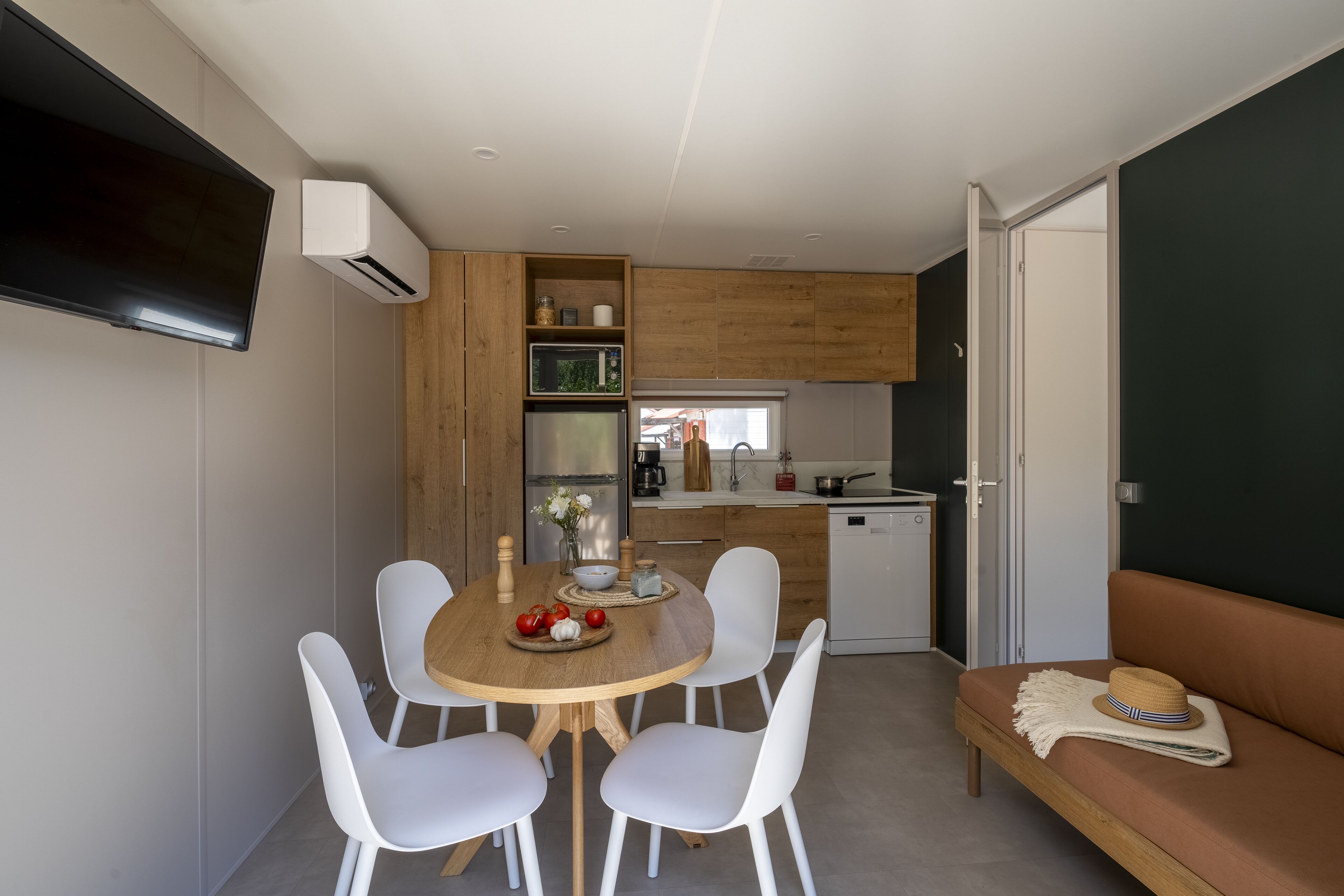 A compact living space with a dining area, kitchenette, and seating area.