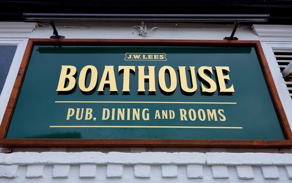 A sign for J.W. Lees Boathouse, indicating it offers pub, dining, and rooms.