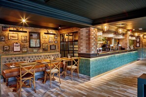 A restaurant with a bar area, wooden flooring, and a brick accent wall. - The Boathouse & Riverside Rooms (Chester)