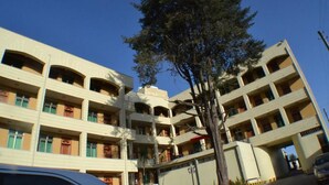 A multi-story hotel with balconies, a central courtyard, and a tree in front. - Fasil International Hotel (Addis Ababa)