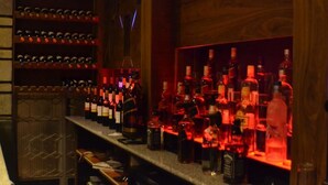 A bar area with shelves of wine bottles and a variety of liquor bottles. - Fasil International Hotel (Addis Ababa)