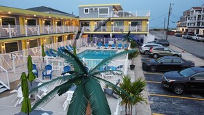 A hotel with a pool, multiple balconies, and a parking lot. - Ala Kai Motel (Wildwood Crest)