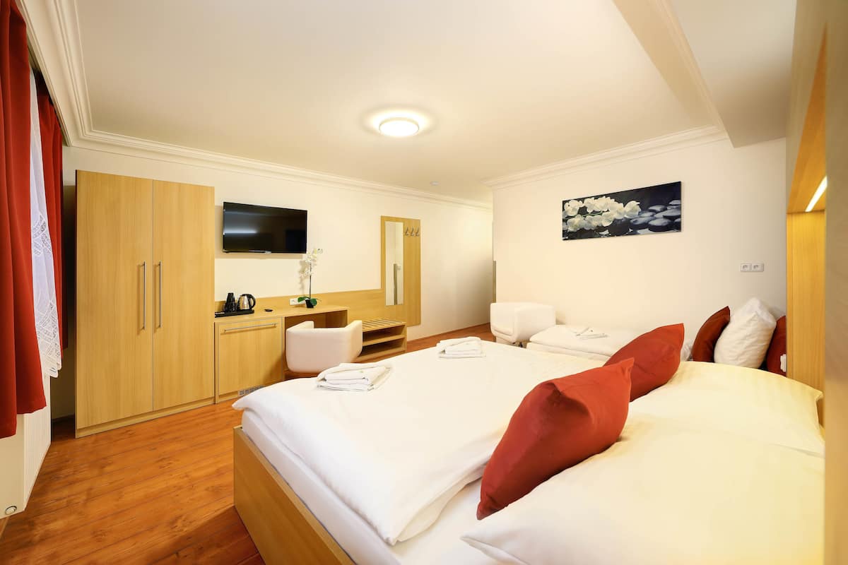 Een hotelkamer met een bed, een bureau, een stoel, een televisie en een schilderij aan de muur.