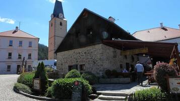 A stone building with a sloped roof and a clock tower.
