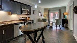 Una cucina moderna con mobili scuri, elettrodomestici in acciaio inossidabile e luci a sospensione.