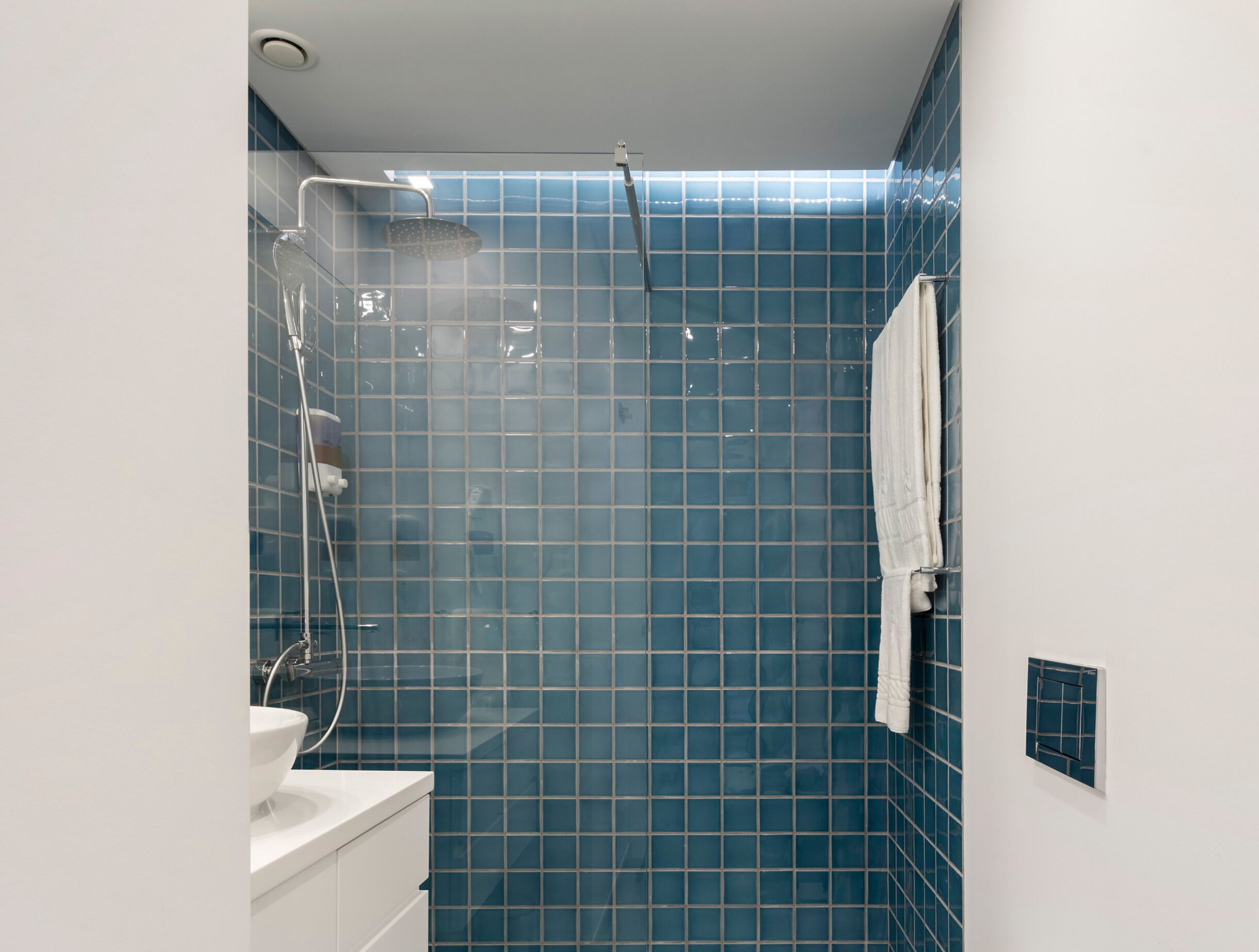 Ein Badezimmer mit Dusche, Waschbecken und Handtuchhalter.