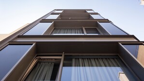 Un edificio moderno con varios pisos, amplias ventanas y techo plano.
