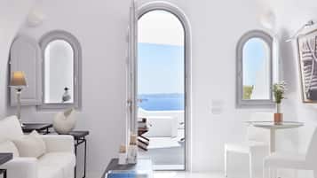 Suite Deluxe, vista mare (Caldera View) | Area soggiorno | TV a schermo piatto 42 pollici con canali satellitari, TV