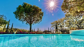 Een buitenzwembad en ligstoelen