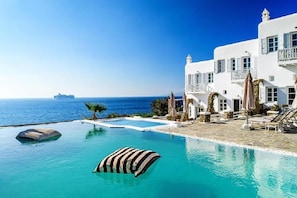A white building with a pool and a view of the sea. - Apanema Aegean Luxury Hotel (Mykonos)