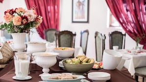 A dining table set with various dishes, a milk jug, and a floral centerpiece. - Alveston Manor (Middelburg)