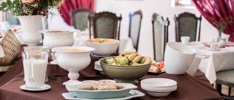 A dining table set with various dishes, a milk jug, and a floral centerpiece.