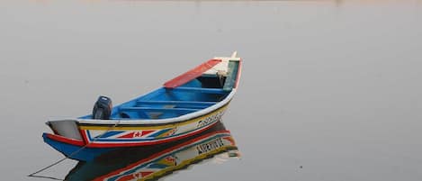 A stationary boat with a colorful design on a calm body of water.