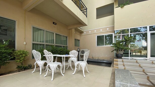 A building with a balcony, white outdoor furniture, and potted plants. - C.a.p. Mansion Hotel (Wichit)