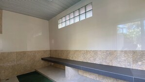 A room with a bench, a small window, and a tiled wall. - C.a.p. Mansion Hotel (Wichit)