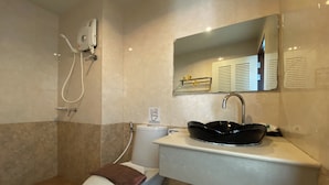 A bathroom with a toilet, bidet, sink, and mirror. - C.a.p. Mansion Hotel (Wichit)
