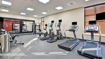 A gym with treadmills, elliptical machines, and weight machines.