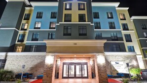 Un hotel de varios pisos con un llamativo letrero de "Homewood Suites" en la parte superior.