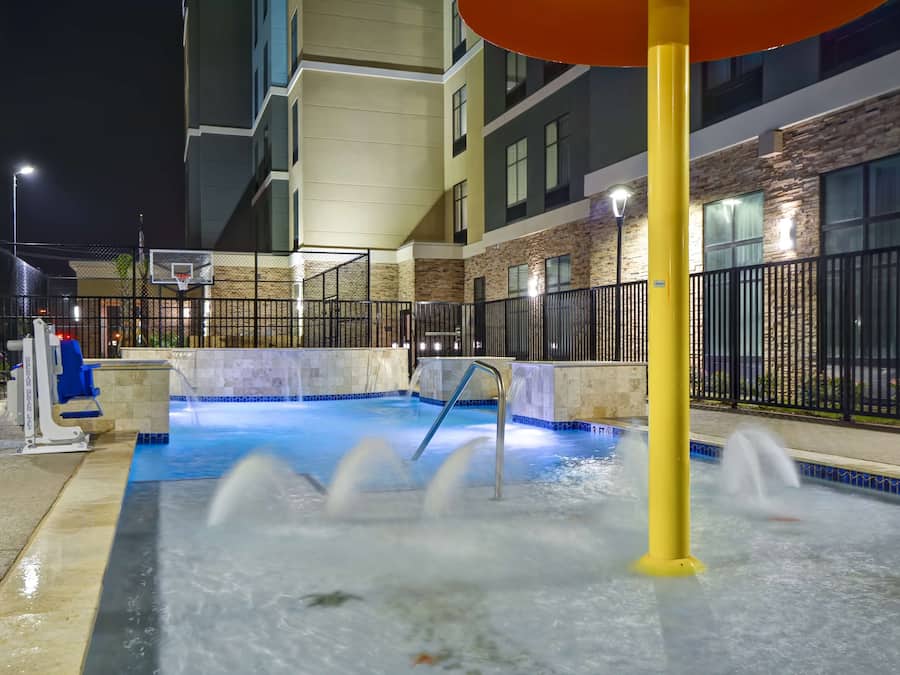 Een buitenzwembad, ligstoelen bij het zwembad